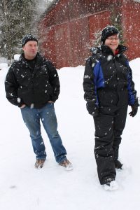 Alapeuran tilan isäntä ja emäntä, lunta sataa.