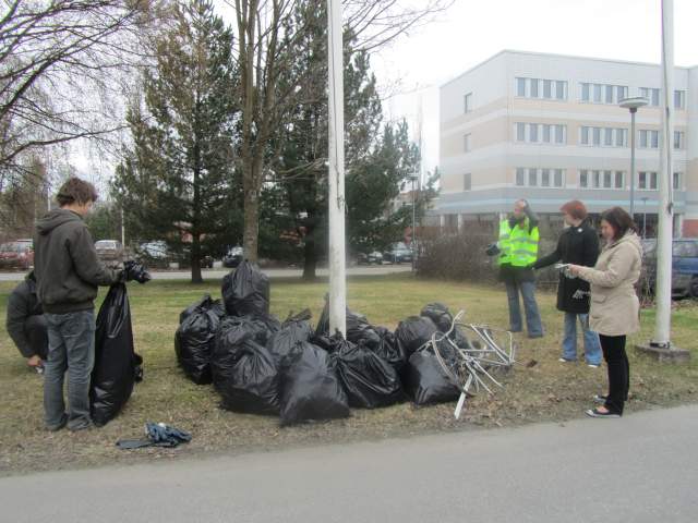 Siivoustalkoot Mataran pihassa, roskasäkkejä lipputangon ympärillä.