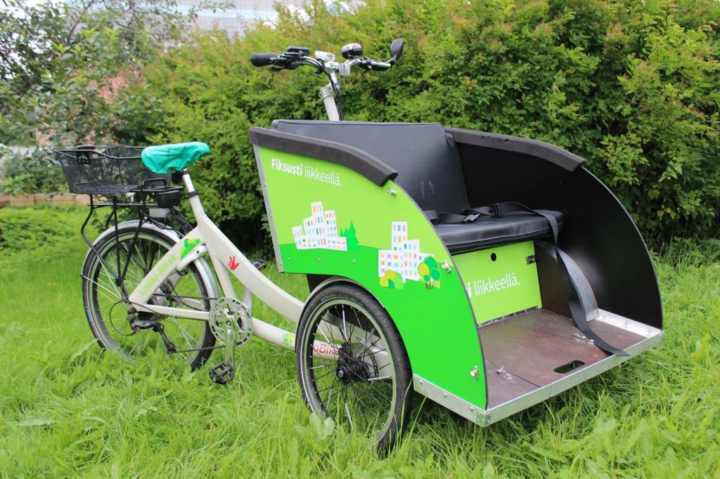 Kolmipyöräinen, sähköavusteinen TrioBike Taxi –merkkinen riksa.