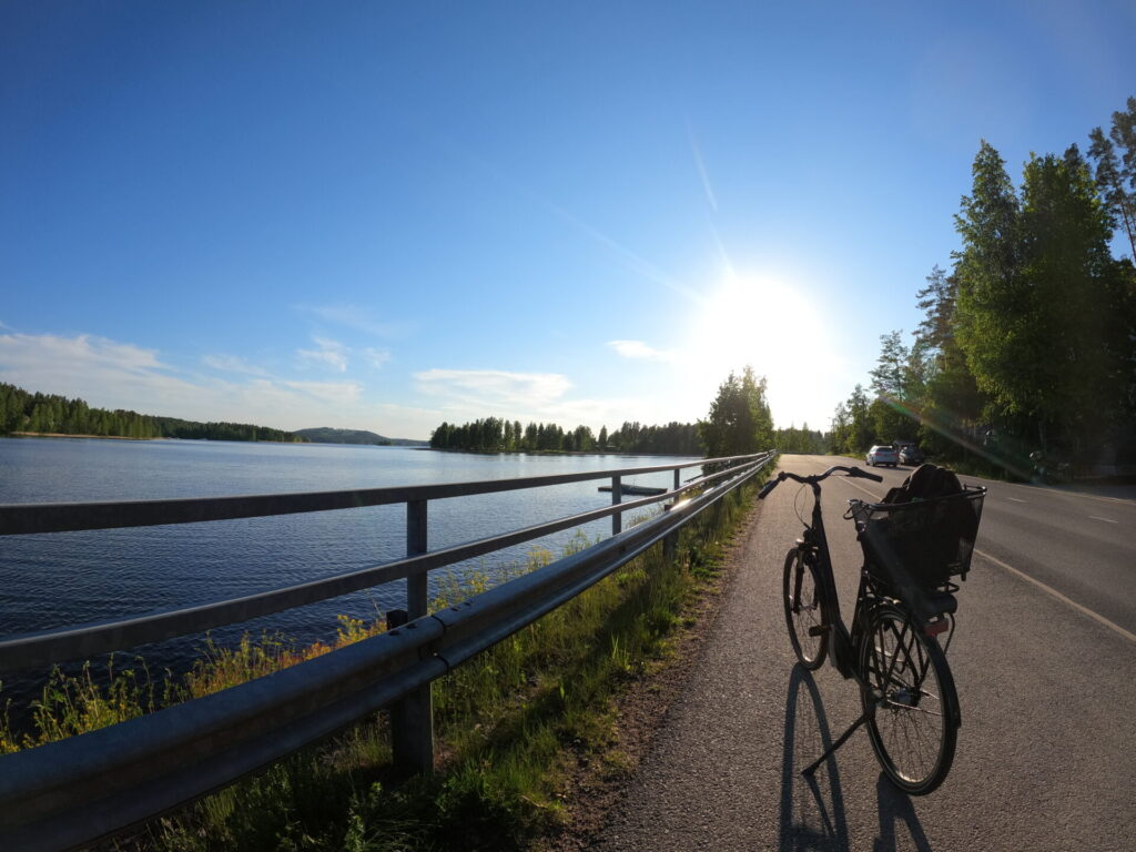 Polkupyörä, kaide, järvinäköala, sininen taivas, aurinko paistaa