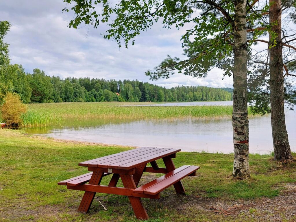 Uimaranta, edessä pöytäryhmä, oikealla koivuja