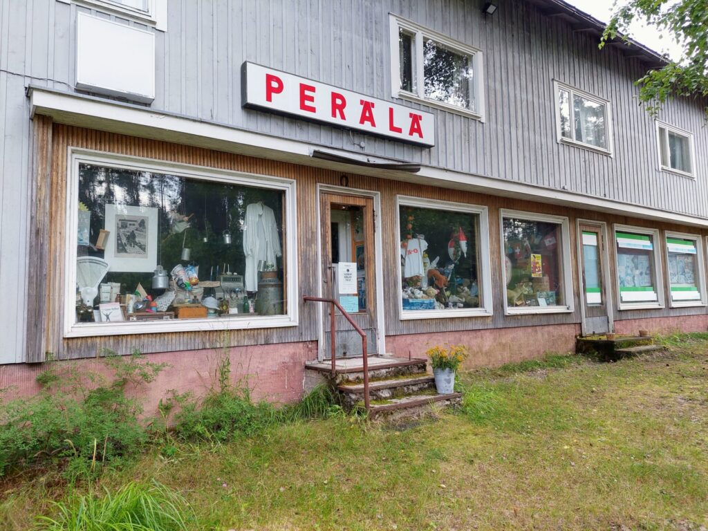 Perälän museokauppa, harmaa puurakennus, näyteikkunat