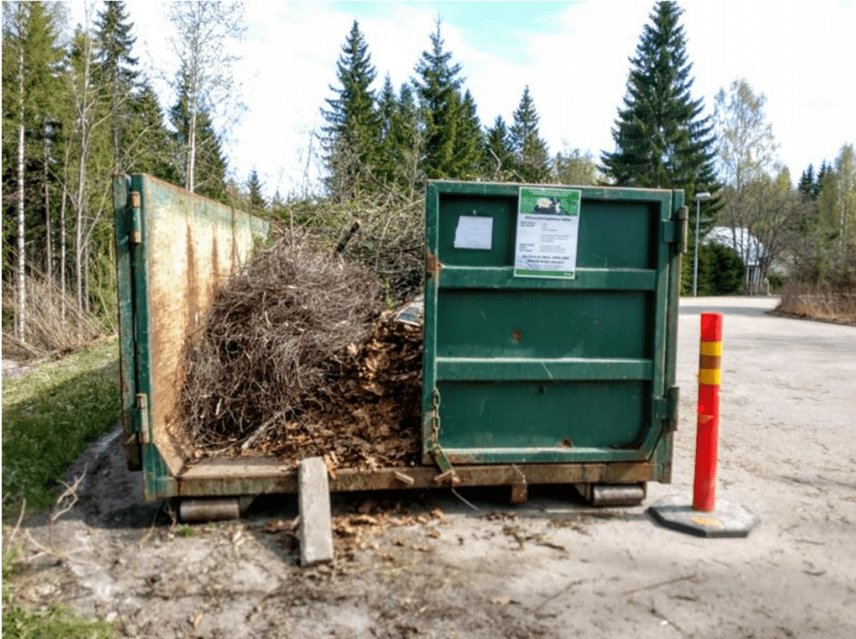 Avonainen siirtolava pihassa, lavalla risuja.