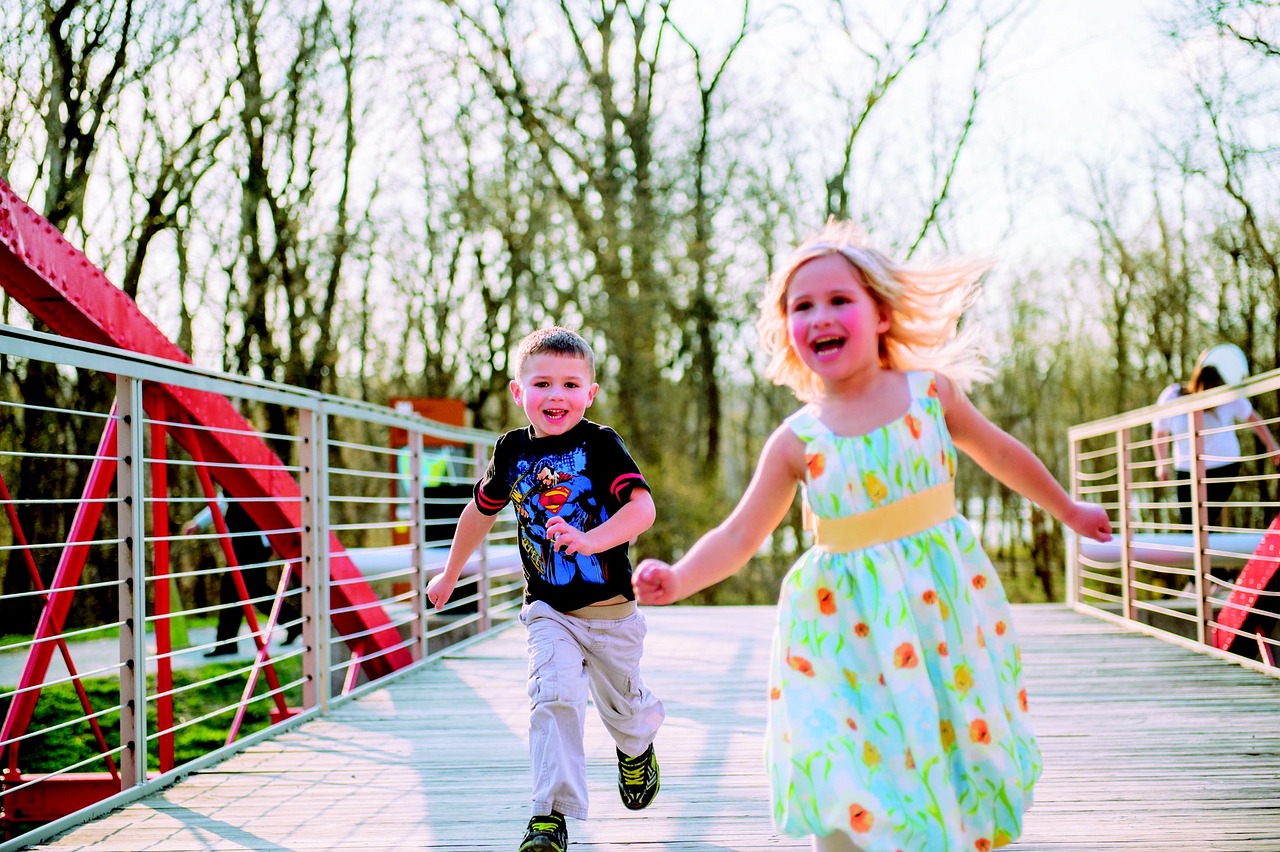 Kaksi lasta juoksee iloisena