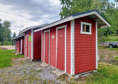 Kolme pientä punaista rakennusta peräkkäin.